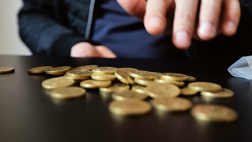 Fifty cent euro coins counted on black surface reflect symbolic savings effort