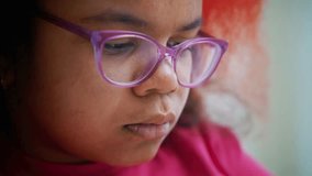 Young girl wearing purple glasses intently reading book, displaying deep concentration with focused expression and slightly pursed lips while absorbed in literary world - Powered by Shutterstock - Get 15% off with code: PIKWIZARD15