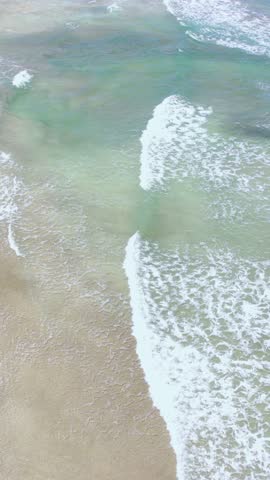 Vertical Drone Shot of Caribbean Sea Waves Breaking on White Sand and Beach in Costa Rica