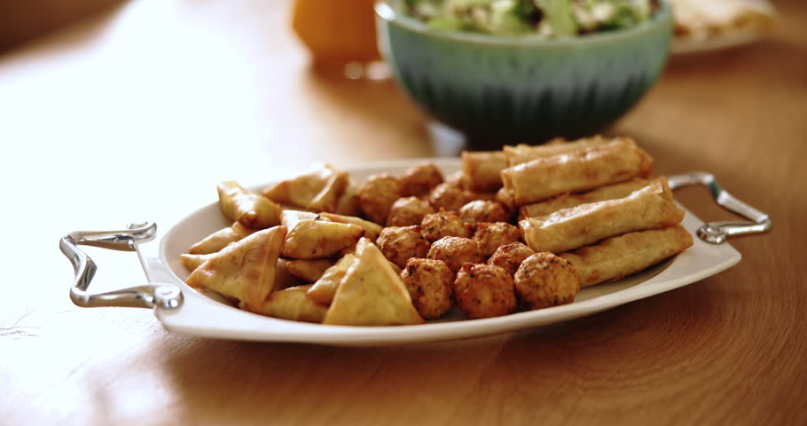 Food, platter and lunch on table house for Eid Mubarak, Islamic celebration and nutrition snack. Samosa, meal and hosting for Ramadan iftar, fasting tradition and dish for culture gathering in lounge