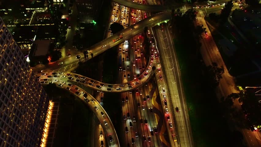 Epic aerial of Los Angeles night traffic congestion, glowing city lights, roads