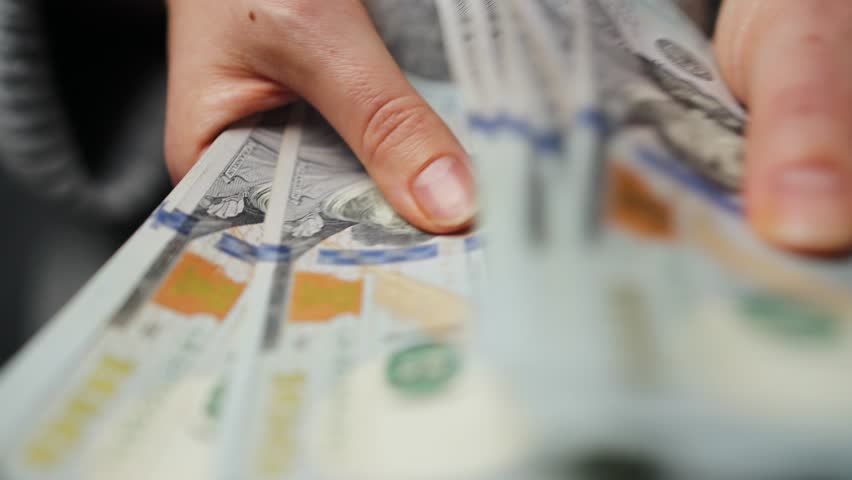 Woman counting US Dollar bills, close-up