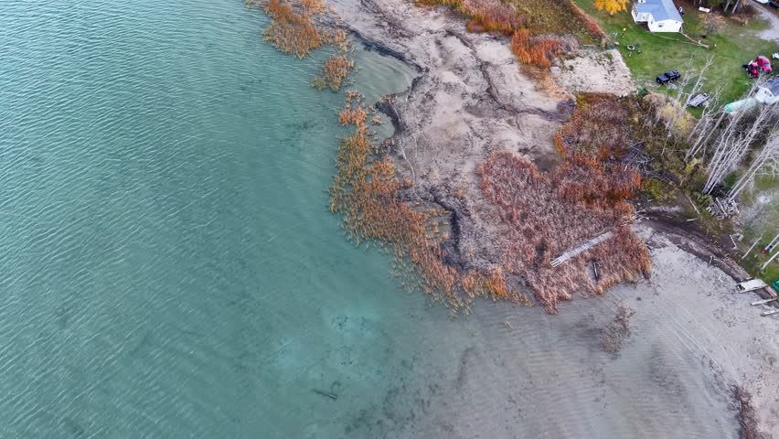 Aerial drone shot of Lake Superior coastline in Michigan’s Upper Peninsula, featuring rocky shoreline and clear blue water