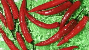 Fresh hot chili peppers falling into the water top view, splashing water, slow motion. - Powered by Shutterstock - Get 15% off with code: PIKWIZARD15