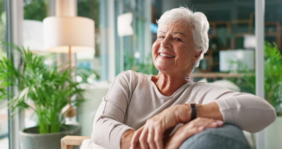 Relax, calm and face of old woman on sofa for retirement, nursing home and peace. Smile, elderly care and happiness with portrait of senior person in living room of house for wellness as pensioner
