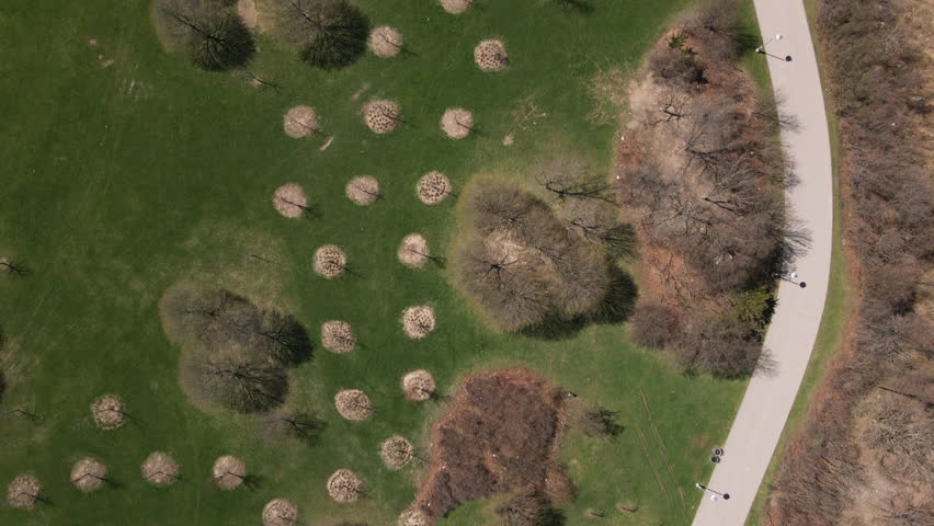 Hamilton, Ontario, Canada - A Peaceful Walking Path Winds Through Budding Trees Along the Lakefront - Vertical Shot
