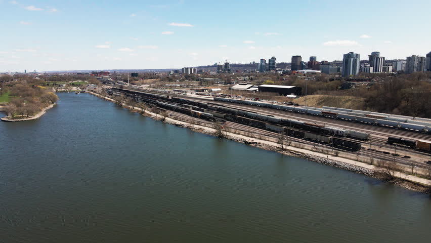 The Calm Waterfront Meets the Bustle of the City Skyline, Blending Nature and Urban Life in Hamilton, Ontario, Canada - Aerial Pullback Shot