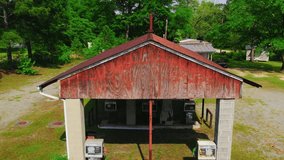 Drone shot of a decaying rural gas station in Georgia, with rusted roof, old pumps, and surrounding greenery in quiet isolation. - Powered by Shutterstock - Get 15% off with code: PIKWIZARD15
