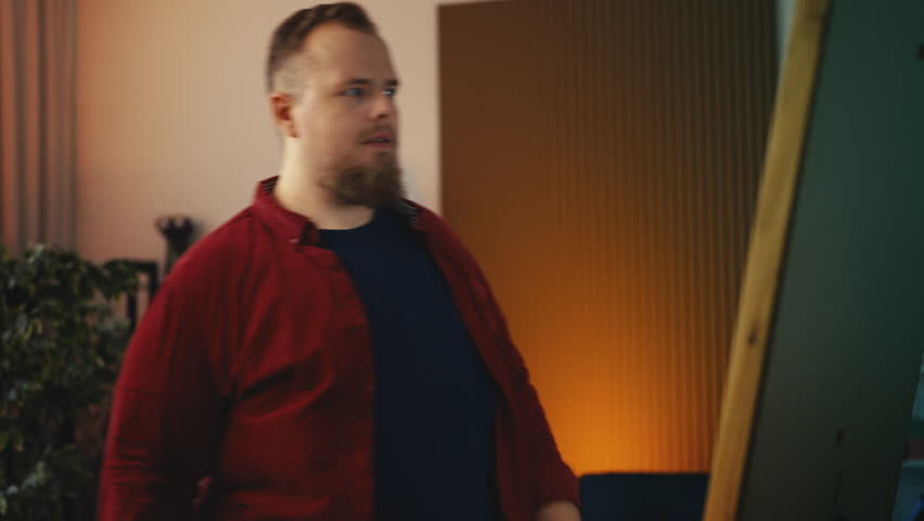 Young plus-size man trying to button shirt near mirror, extra weight concern