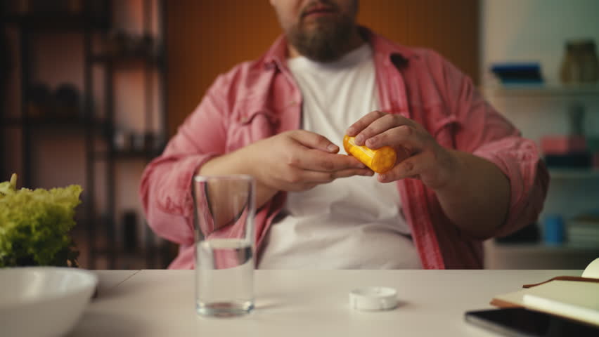 Overweight man takes appetite-suppressing supplement, works on weight reduction