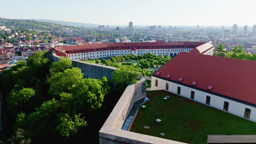Breathtaking drone footage of the Baroque-style garden in Bratislava Castle during morning light, surrounded by historical fortress walls and a modern city skyline.