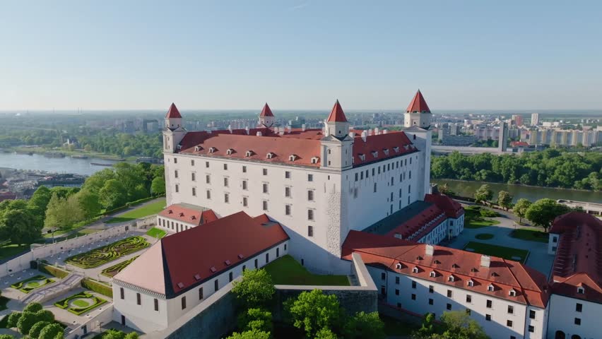 Stunning aerial footage of Bratislava Castle and the Danube River captured in the early morning light, featuring the historic Old Town, iconic bridges, and the evolving city skyline.