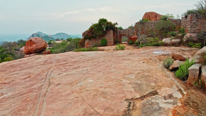 Ancient Gateway with trees and hill mountain at Rachakonda Fort, telangana, india. day time, push in, over take, drone shot, 4k.