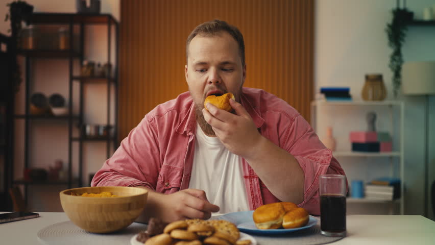 Large-bodied man enjoying high-calorie snack, struggling with eating disorder