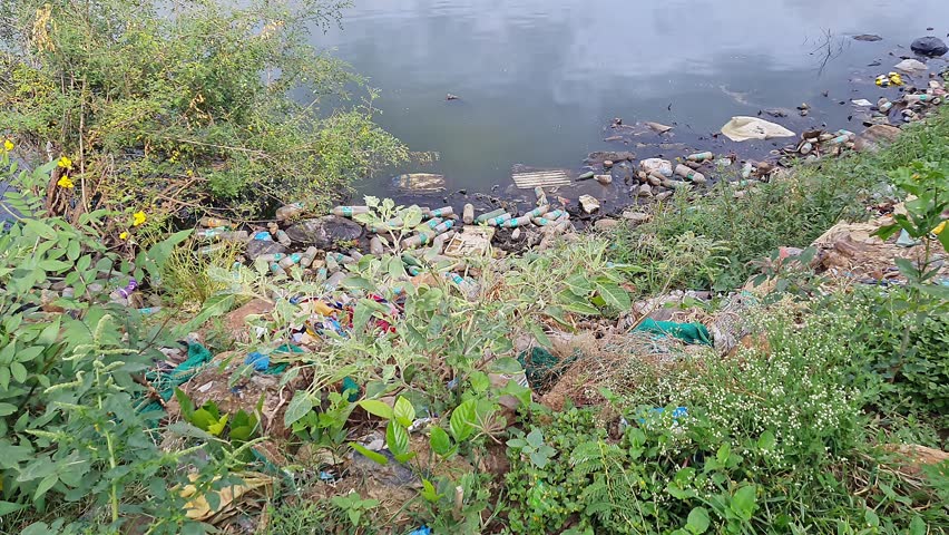 A video of rural lake filled with plastic litter,waste and dirty water, environmental pollution and lack of proper waste management. awareness campaigns.global ecological issues