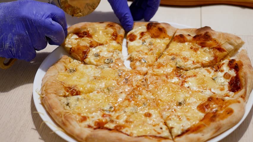 Cutting Pizza with a Round Cutter Knife. Close-up of Delicious Pizza Being Cut into Pieces. Person Slicing a Meal into Multiple Slices