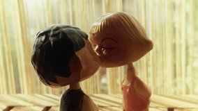 Romantic Kissing Couple Toys on Wooden Table in Warm Sunlight - Powered by Shutterstock - Get 15% off with code: PIKWIZARD15