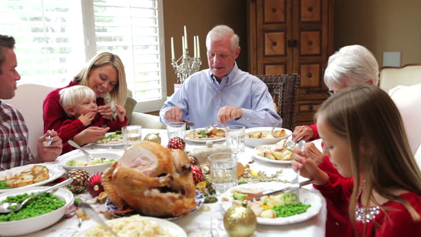 Camera tracks across table as extended family sit and enjoy thanksgiving dinner. Shot on Canon 5d Mk2 with a frame rate of 30fps