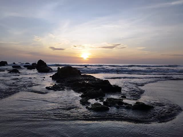 A breathtakingly colorful sunrise over Nilaveli Beach, painting the skies above the serene eastern coast of Sri Lanka with hues of gold, pink, and orange.

