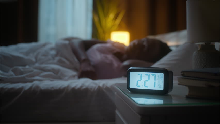Unhappy sleeping napping African American woman female girl turning side sleepless can't sleep insomnia health disorder discomfort awake problem lying down uncomfortable bed at home bedroom dark night