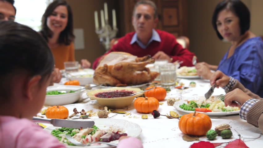 Camera tracks across table as extended family sit and enjoy thanksgiving dinner. Shot on Canon 5d Mk2 with a frame rate of 30fps