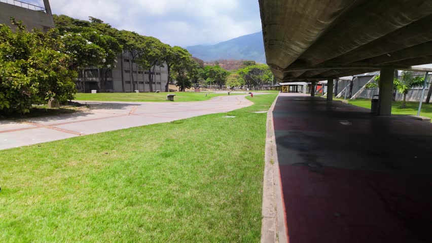 POV walking through UCV campus, Plaza el Rectorado, Central University of Venezuela World Heritage Site with green spaces and buildings, La Casa que Vence la Sombra. Caracas Venezuela