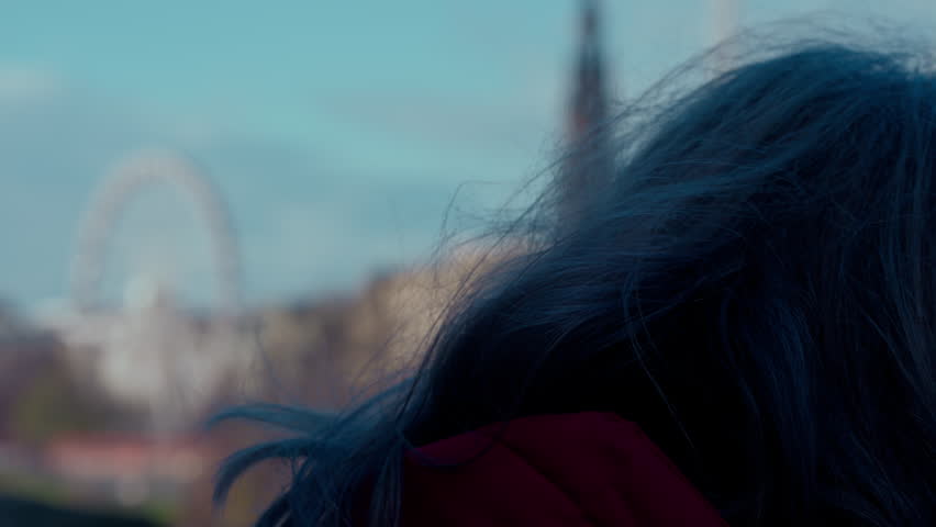 Grey-Haired Woman Overlooking Edinburgh Cityscape with Blurred Scott Monument and Star Flyer Ride in Daytime Slow Motion