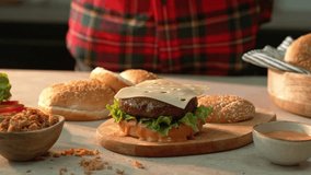 4K slow motion video of a cheese slice landing perfectly on a sizzling burger patty with lettuce, sauce and bun. A juicy, appetising food shot ideal for cooking, fast food, and grilling content. - Powered by Shutterstock - Get 15% off with code: PIKWIZARD15