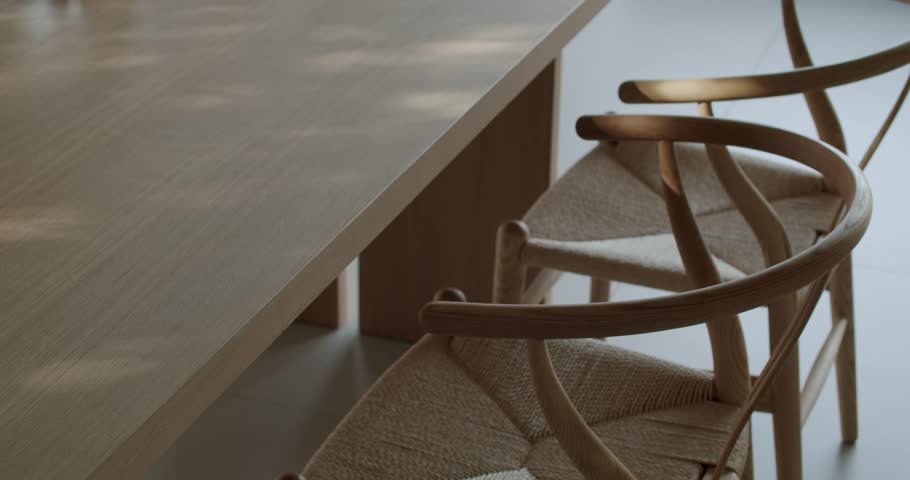 Modern dining room table and chairs made of light wood and woven natural fiber. Sunlight creates a calm and inviting atmosphere. Perfect for interior design, home decor, and lifestyle content.