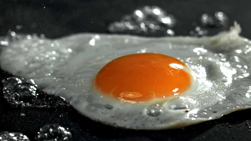 The egg is fried in a pan. Filmed on a high-speed camera at 1000 fps. High quality FullHD footage