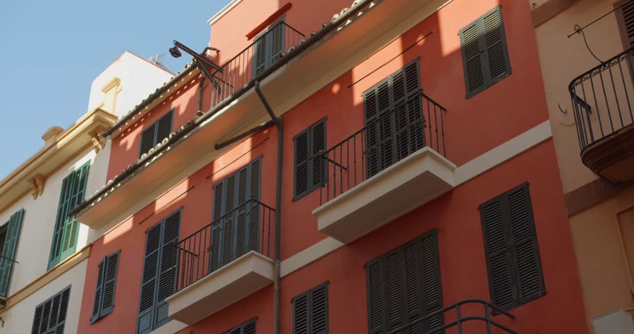 Capturing of spainsh architecture colorful buildings with small balconies and windows in Palma de Majorca, Spain. 4k.
