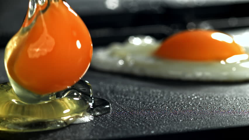 The broken egg falls into the pan. Filmed on a high-speed camera at 1000 fps. High quality FullHD footage
