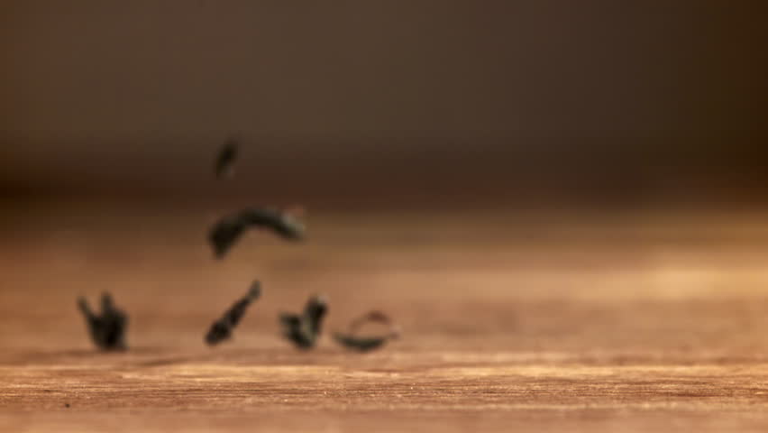 Dry tea leaves fall on a wooden table. Filmed on a high-speed camera at 1000 fps. High quality FullHD footage