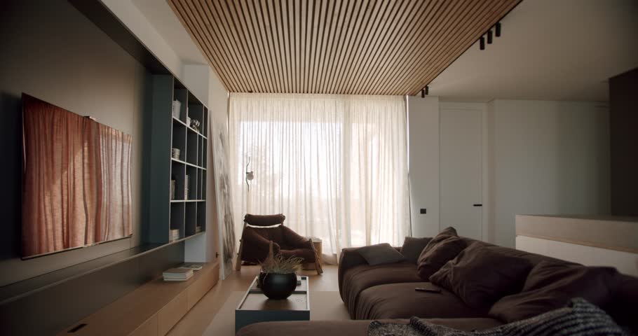 Modern living room interior with comfortable furniture and stylish decor. Natural light through sheer curtains creates warm ambiance. Minimalist design neutral color palette give sophisticated feel