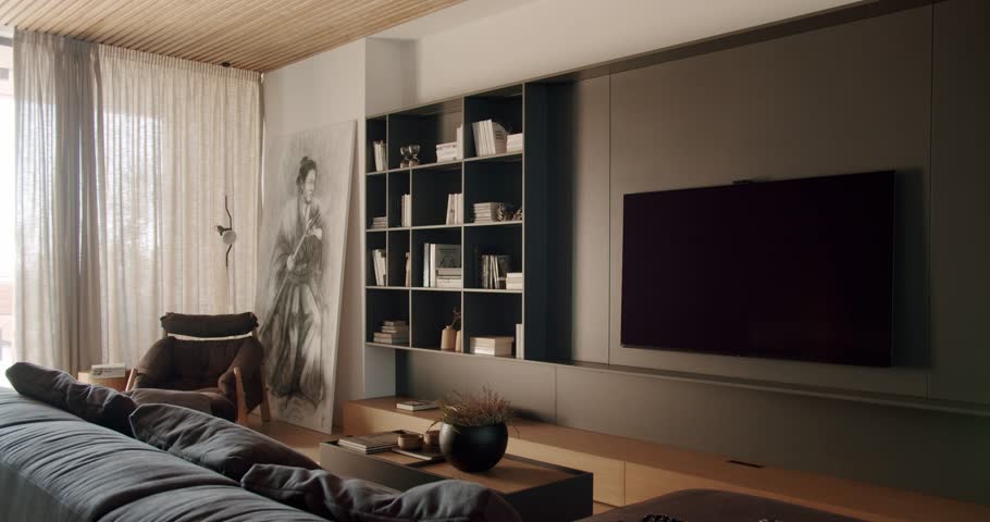 Modern living room interior with TV, shelves, comfortable sofa and stylish decor. The room is filled with natural light and has a cozy atmosphere. Perfect for relaxation and entertainment.