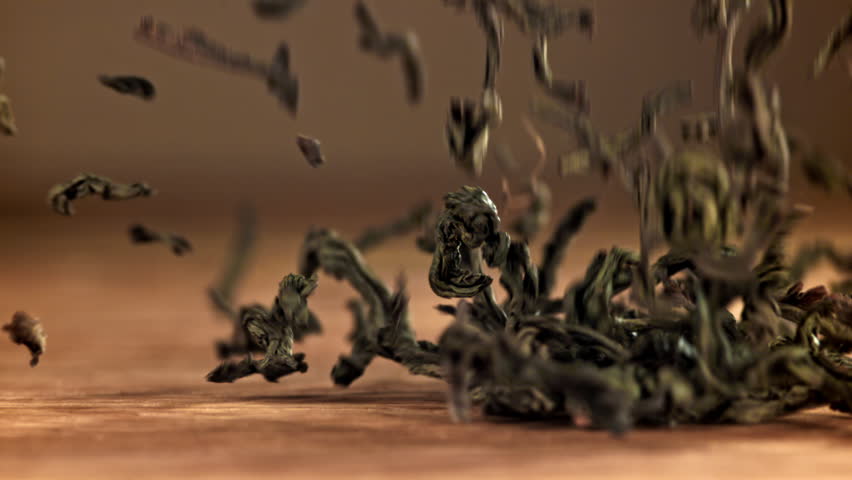 Dry tea leaves fall on a wooden table. Filmed on a high-speed camera at 1000 fps. High quality FullHD footage