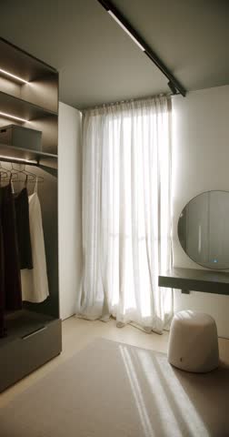 Modern walk-in closet with minimalist design, featuring built-in wardrobe, vanity table, and soft, sheer curtains. Sunlight streams through the window, creating a bright and airy atmosphere.