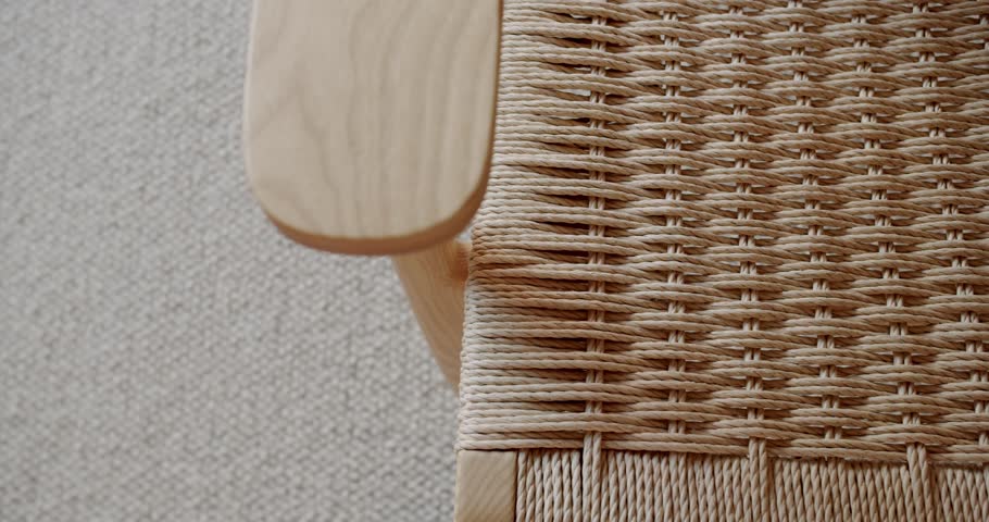 Close-up of a hand-woven chair seat made of natural fiber cord. The craftsmanship and intricate detail are highlighted, showcasing the texture and pattern of the woven design.
