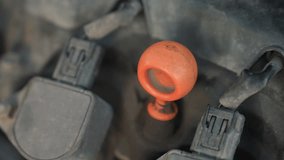 Extreme close up of car engine showing red dipstick fully reinserted after oil level check during cold weather vehicle maintenance with snow-covered background - Powered by Shutterstock - Get 15% off with code: PIKWIZARD15