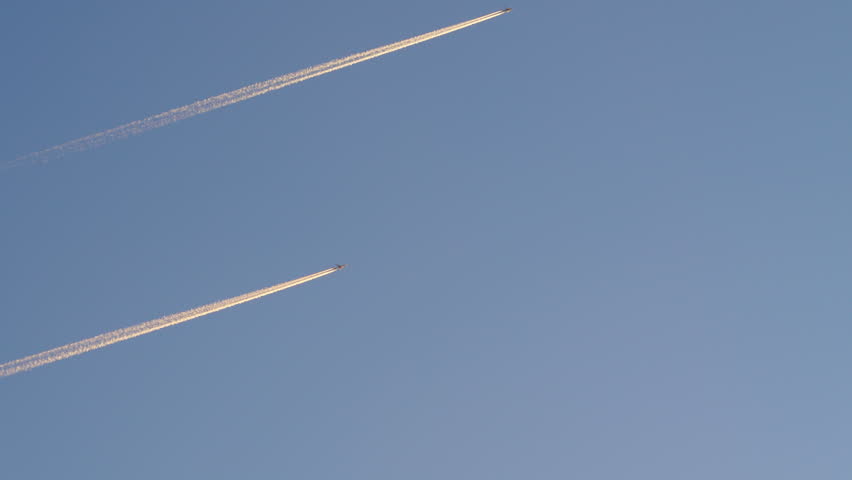 Three airplanes are flying high in the clear blue sky, leaving white trails behind them. Passenger planes on their way to their destination, Business travel or vacation