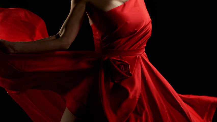 Brunette Woman in Ruby Red Dress Posing Against a Black Background . Filmed on High Speed Cinematic Camera in Super Slow Motion