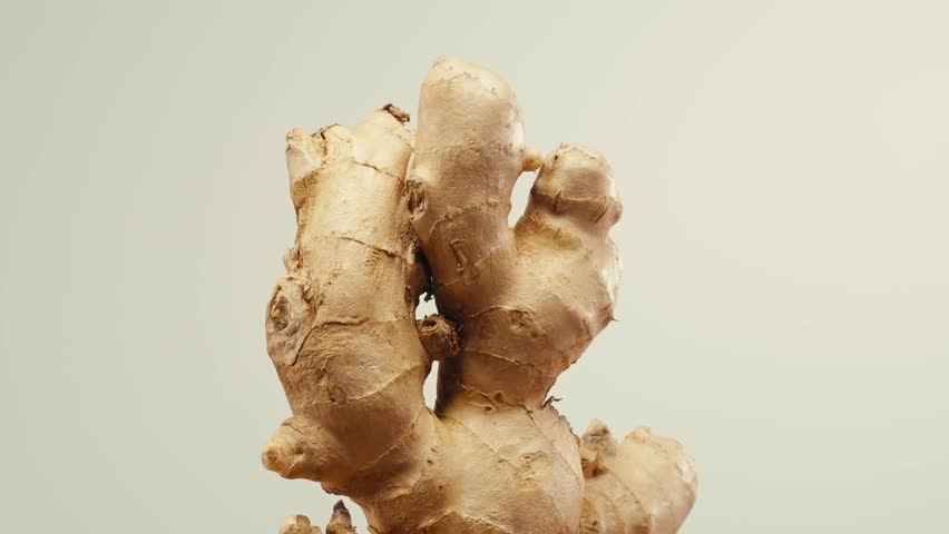 Ginger root and sliced on old plank with nature background. Close-up, food texture, tea lemonade ingredient in bar.