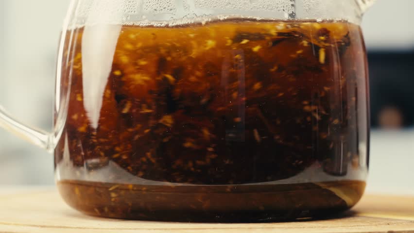 Ginger tea, freshly brewed black organic herbal tea with ginger, mint and lemon in a glass teapot, medication healthy.
