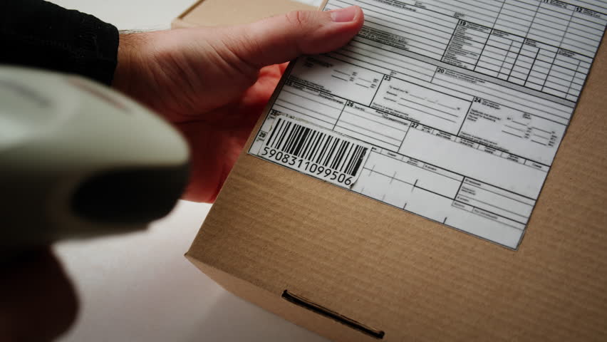 Scanner scan delivery box in storage, E-commerce shop, man packing goods and clothes second hand delivery market, courier Packaging and Shipping Workspace with Supplies and Technology, online sales.
