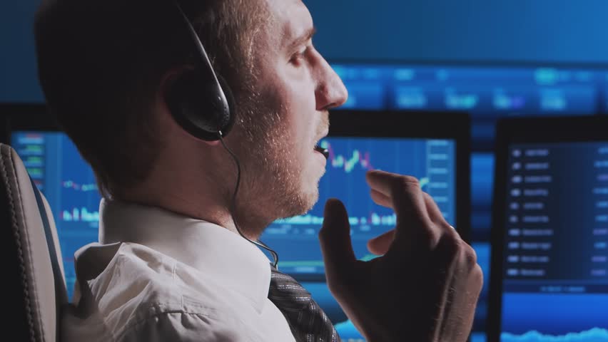 Trader works in office using workstation and analysis technology. Workplace of professional crypto exchange broker. Close-up portrait. Global financial markets, business strategy, currency exchange