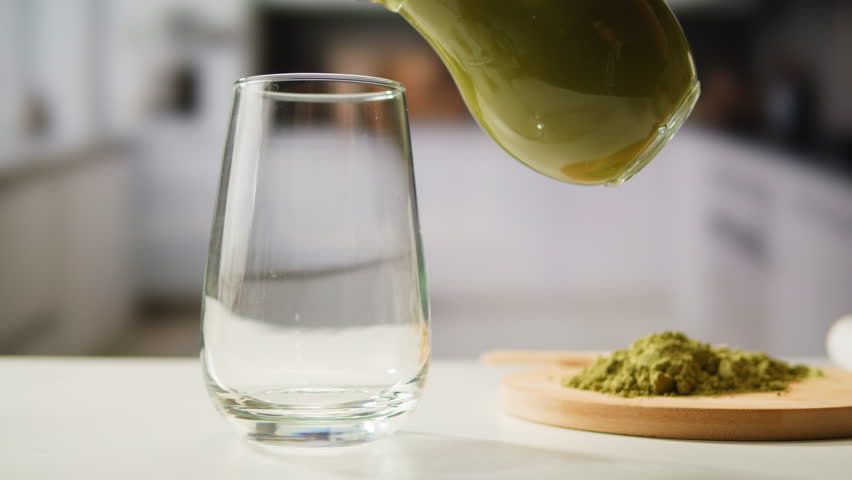 Matcha green tea cooking process, japanese powder green tea in a bowl with bamboo whisk, macro close up in cafe of powder green tea. 