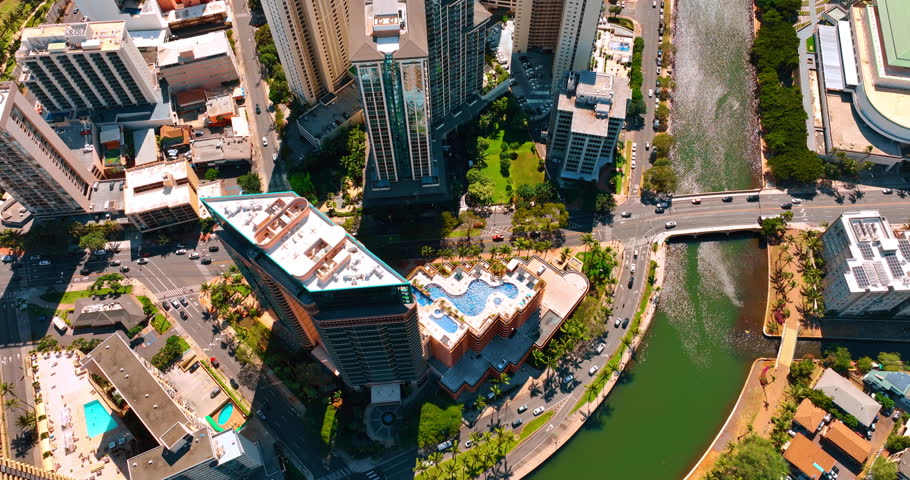 Going up over the high-rise building with the swimming pool on top. Ala Wai Canal is sparkling in the sun. Honolulu, Hawaii, USA.