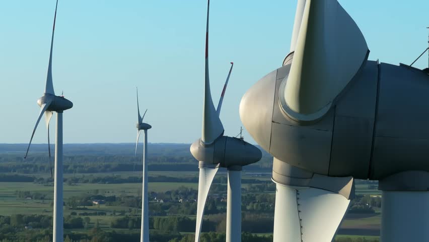 Wind farm at sunrise, wind generators aerial view, windmills generating electricity, drone shot, golden hour, green renewable energy, wind turbine