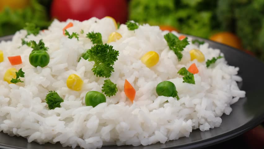 Cooked rice close-up with diced carrots and green peas