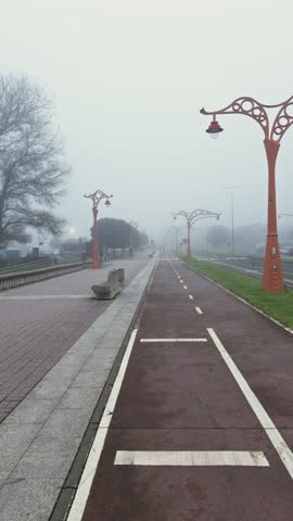 Foggy city bike path with decorative lamp posts